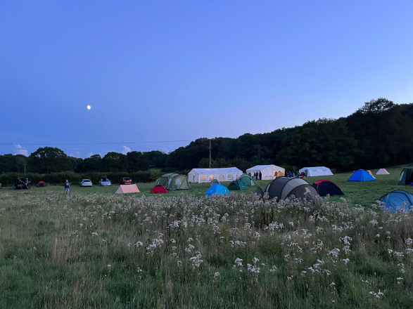 A picture from last year's summer camp – tents under a blue sky.