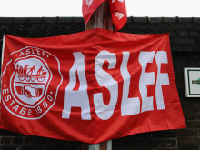 A red Aslef flag, with a Southern rail logo visible in the background