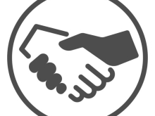 Icon of two hands, one white and one black, shaking inside a circle, symbolising agreement, partnership, or cooperation.