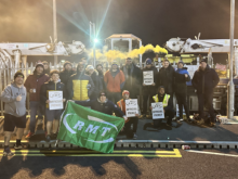 RMT Hitachi rail picket line; striking workers hold placards and a large green RMT flag