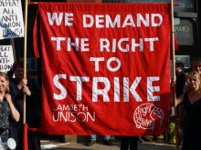 A large red banner with the slogan "We demand the right to strike" and "Lambeth Unison" embroidered on it