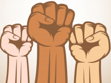 Three raised fists of different skin colours